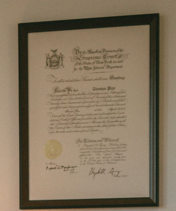 The framed certificate of admission to the New York bar, made out to Thomas Plan.